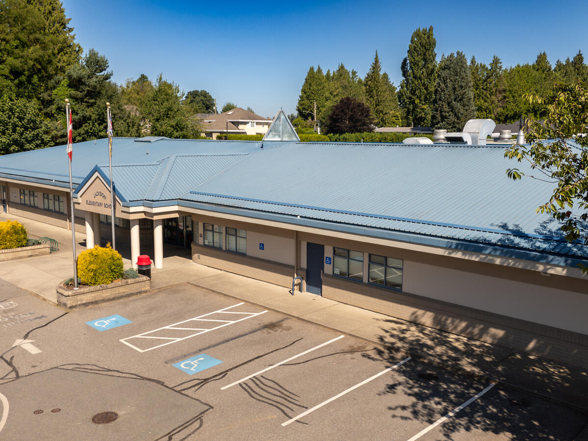 Exterior of the entrance to an Elementary school with trees and a blue sky in the background