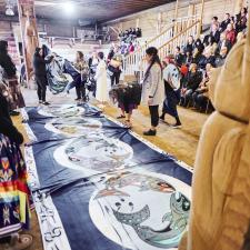 Blankets are placed on the ground of the longhouse