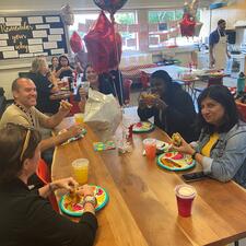 Group of support staff sitting down enjoying starbucks and treats